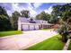 Home features a three-car garage, expansive driveway, and manicured lawn with decorative flower bed at 4149 Yancey Rd, Douglasville, GA 30135