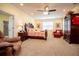 Spacious main bedroom featuring carpet floors, ceiling fan, wooden bed, and a cozy red chair at 4149 Yancey Rd, Douglasville, GA 30135