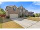 Brick and stone home with a well-maintained lawn, complemented by an ample driveway and lush greenery at 4279 Two Bridge Dr, Buford, GA 30518
