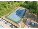 Aerial view of a well-maintained tennis court, surrounded by lush greenery and bordering a pool area at 4279 Two Bridge Dr, Buford, GA 30518