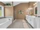 Relaxing bathroom featuring dual sinks, soaking tub, separate shower, and neutral tiling at 3311 Lost Meadows Ln, Buford, GA 30519