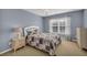 Cozy bedroom featuring a patterned quilt, neutral carpeting and a window with natural light at 3311 Lost Meadows Ln, Buford, GA 30519