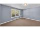 Bedroom featuring a window, gray walls, tan carpeting, and white base molding along the walls at 3311 Lost Meadows Ln, Buford, GA 30519