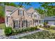 Lovely two-story home featuring a brick facade, shutters, and landscaped garden at 3311 Lost Meadows Ln, Buford, GA 30519