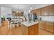 Open-concept kitchen with stainless steel appliances, eat-in dining area, and hardwood flooring at 3311 Lost Meadows Ln, Buford, GA 30519