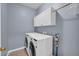 Functional laundry room with side-by-side washer and dryer and ample storage space at 3311 Lost Meadows Ln, Buford, GA 30519
