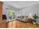 Bright sitting room features hardwood floors, a comfortable sofa, and large windows offering natural light at 3311 Lost Meadows Ln, Buford, GA 30519