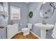 Cozy powder room with white vanity, pedestal sink, and decorative wall accents at 3311 Lost Meadows Ln, Buford, GA 30519