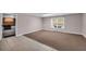 Room featuring tan carpeting and tile flooring along with a window view and tan colored walls at 3311 Lost Meadows Ln, Buford, GA 30519
