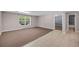 Room featuring tan carpeting, gray walls, tile flooring, a window, and a door at 3311 Lost Meadows Ln, Buford, GA 30519