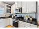Kitchen featuring white cabinets, stainless steel appliances, and black granite countertops at 419 Farmwood Way, Canton, GA 30115