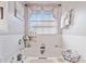 Spa-like main bathroom featuring a soaking tub, a window, neutral walls, and tiled floors at 419 Farmwood Way, Canton, GA 30115