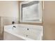Modern bathtub with a tiled surround and a window offering natural light at 4316 Constellation Blvd, Snellville, GA 30039
