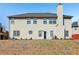 Two-story home with beige siding, a chimney, and sliding glass door to backyard at 4316 Constellation Blvd, Snellville, GA 30039