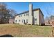 Two-story home with beige siding, a chimney, and sliding glass door to backyard at 4316 Constellation Blvd, Snellville, GA 30039