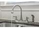 Close-up of a stainless steel kitchen sink and faucet with granite countertops and white backsplash at 4316 Constellation Blvd, Snellville, GA 30039