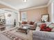 Cozy living room with neutral paint, plush seating, decorative rug and an open archway to the dining area at 4316 Constellation Blvd, Snellville, GA 30039