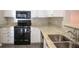 Updated kitchen features granite countertops, stainless steel sink, and black appliances at 101 Spring Heights Se Ln # 1, Smyrna, GA 30080