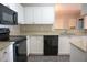 Kitchen area with granite counters, white cabinets, black appliances, and tile flooring at 101 Spring Heights Se Ln # 1, Smyrna, GA 30080