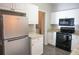 Kitchen featuring stainless steel refrigerator, white cabinets, granite counters, and tile flooring at 101 Spring Heights Se Ln # 1, Smyrna, GA 30080