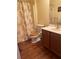 Cozy bathroom with floral shower curtain, wood toilet seat, and wooden vanity at 119 Holiday Rd # 704, Buford, GA 30518
