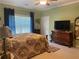 Well-lit bedroom featuring ceiling fan and floral bedding with wood furniture at 119 Holiday Rd # 704, Buford, GA 30518