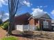 Brick home featuring a white picket fence, trimmed hedges, mature trees, and a well-manicured lawn and garden at 119 Holiday Rd # 704, Buford, GA 30518