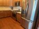 Modern kitchen featuring stainless steel appliances, wooden cabinetry, and a view of the hardwood floors at 119 Holiday Rd # 704, Buford, GA 30518