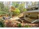 Backyard featuring a stone patio with seating, a covered deck, and lush landscaping at 129 Ridgetree Ln, Marietta, GA 30068