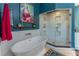 Stylish bathroom featuring a soaking tub, walk-in shower with glass doors, and a modern design with a striking blue accent wall at 129 Ridgetree Ln, Marietta, GA 30068