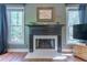 Cozy living room with a fireplace, hardwood floors, and natural light from two large windows at 129 Ridgetree Ln, Marietta, GA 30068