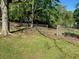 Spacious backyard with a partial fence, mature trees, and a rustic treehouse at 566 Huff St, Lawrenceville, GA 30046