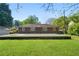 Back view of brick house with a concrete patio surrounded by lush greenery at 566 Huff St, Lawrenceville, GA 30046