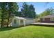 Spacious backyard with brick home and detached garage on a sunny day at 566 Huff St, Lawrenceville, GA 30046