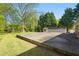Backyard featuring patio and detached garage, complemented by mature trees and lawn at 566 Huff St, Lawrenceville, GA 30046