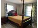 Traditional bedroom features a four poster bed, wood floors, and bright windows, offering a cozy and inviting space at 566 Huff St, Lawrenceville, GA 30046