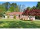 Quaint brick home featuring a red roof, a lush green lawn and a well-manicured lawn at 566 Huff St, Lawrenceville, GA 30046