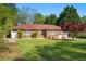 Brick home with a red roof and manicured lawn at 566 Huff St, Lawrenceville, GA 30046