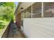 Side of home featuring access door and screened windows, enhanced by brick and white siding at 566 Huff St, Lawrenceville, GA 30046
