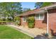 A close up view of the side of a red brick home, showing the gravel landscaping and shrubbery at 566 Huff St, Lawrenceville, GA 30046
