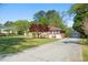 Charming brick home with a well-manicured lawn, a long driveway, and a detached garage at 566 Huff St, Lawrenceville, GA 30046
