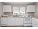 Efficient kitchen features white cabinets, granite counters, and ample countertop space at 566 Huff St, Lawrenceville, GA 30046
