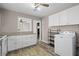 Compact kitchenette with white cabinets, granite counters, and modern washer at 566 Huff St, Lawrenceville, GA 30046