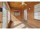 The sunroom has lots of windows, wood paneled walls, and a ceiling fan at 566 Huff St, Lawrenceville, GA 30046