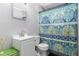 This bathroom features a toilet, sink, mirror, and a shower with a colorful shower curtain at 1302 Brittain Rd, Douglasville, GA 30134