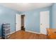 This bedroom features blue walls, hardwood floors, two doors, and ample natural light at 1302 Brittain Rd, Douglasville, GA 30134