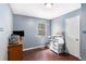 This bedroom features a window overlooking the backyard and a light above at 1302 Brittain Rd, Douglasville, GA 30134