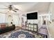 Cozy living room with a dark sofa, large TV, patterned rug, and access to the hallway at 1302 Brittain Rd, Douglasville, GA 30134