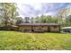 Expansive backyard features a wooden deck, mature trees, and a carport, ideal for outdoor living and entertaining at 284 Zion Wood Rd, Loganville, GA 30052