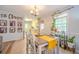 Bright dining room with a wood table, white chairs, natural light, and adjacent kitchen view at 284 Zion Wood Rd, Loganville, GA 30052